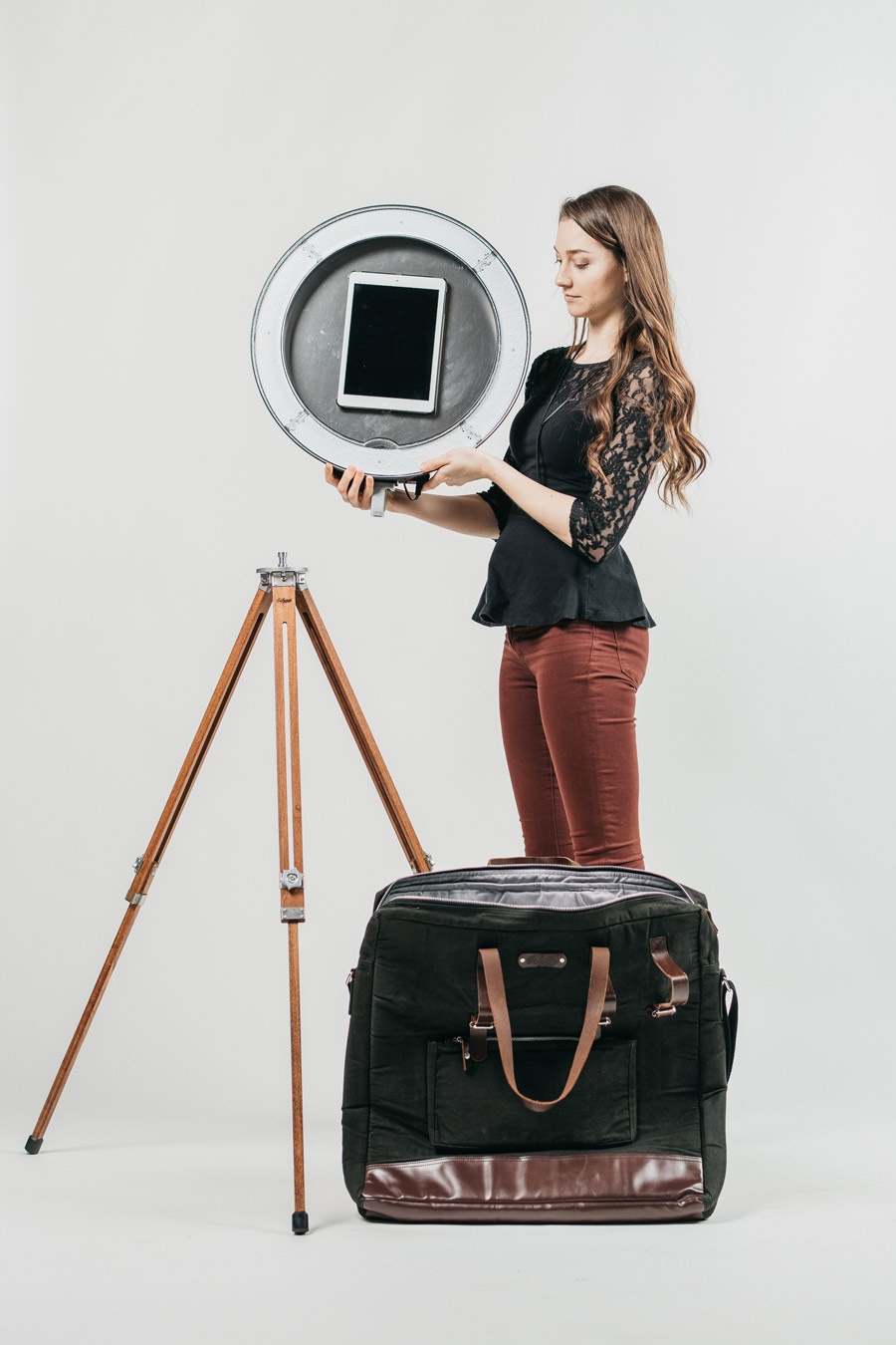 A woman is setting up the Gifyyy kit, attaching the ring-light to the tripod